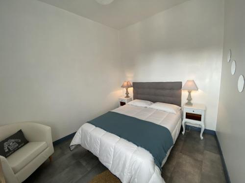 a small bedroom with a bed and a chair at Appartement cosy à Fouras: 1 chambre, proche commerces et plages, Wifi, TV, cuisine équipée - FR-1-709-70 in Fouras