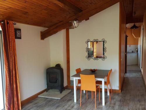 - une salle à manger avec une table et un poêle à bois dans l'établissement Gîte calme avec poêle à bois, terrasse et animaux admis - FR-1-489-470, à Laprugne