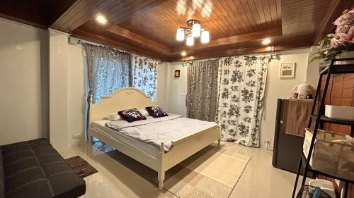 um pequeno quarto com uma cama e uma janela em lemoon house khaoyai em Khao Yai