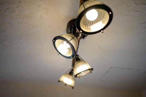 a chandelier with three lights hanging from a ceiling at 日向サーフキャンプ211 in Hyuga