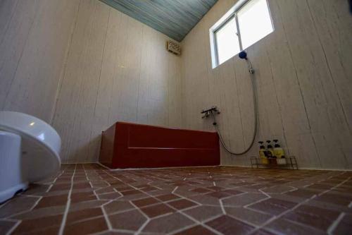 a bathroom with a toilet and a window and a tub at 日向サーフキャンプ211 in Hyuga