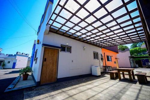 a building with awning over a patio with a wooden door at 日向サーフキャンプ211 in Hyuga