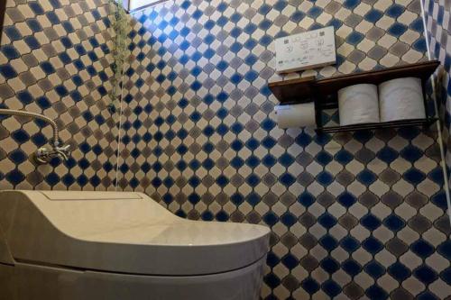 ein Badezimmer mit einem Waschbecken und einer gefliesten Wand in der Unterkunft 日向サーフキャンプ211 in Hyuga