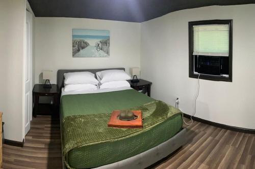 a bedroom with a bed with a green comforter at Field Quarters in Pensacola