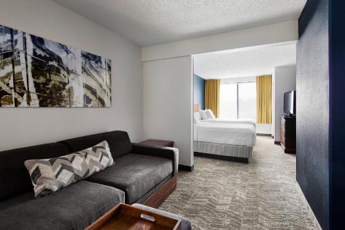 リッチモンドにあるSpringHill Suites by Marriott Richmond North/Glen Allenのソファとベッドのあるリビングルーム