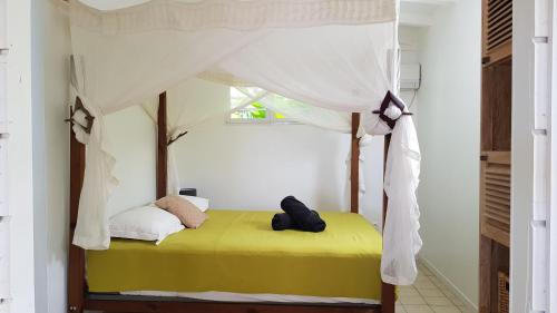 1 dormitorio con 1 cama con dosel en Maison BLEU CORAIL, en Bouillante