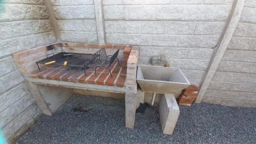 a sink and a bench next to a brick wall at Alojamiento Alquiler Temporario in Las Flores