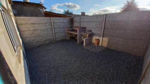 a backyard with a concrete wall and a toilet at Alojamiento Alquiler Temporario in Las Flores