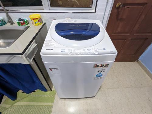 a washing machine sitting in a kitchen next to a sink at Mufeed Homestay in Kampong Wakaf Tengah