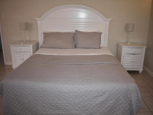 a bedroom with a large bed with two night stands at Harbour View Penthouse in Gros Islet