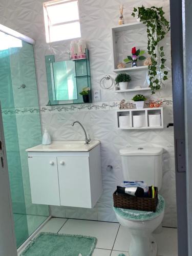 a bathroom with a toilet and a sink and a mirror at Casa Solmar Guriú in Camocim