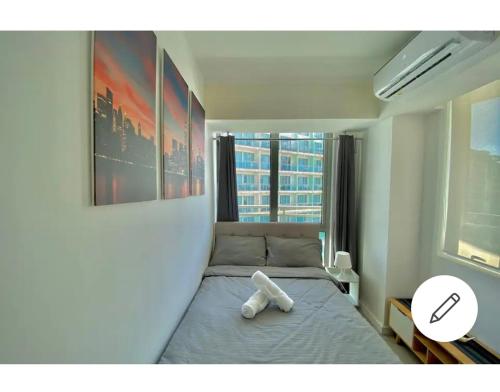 a bedroom with a bed with a white pillow on it at Metro Manila Cityscape Charm at Azure Urban Resort Paranaque near NAIA Airport in Manila