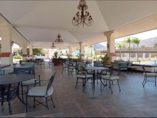 an empty restaurant with tables and chairs and windows at Hermosa casa, sur de Guadalajara in Guadalajara