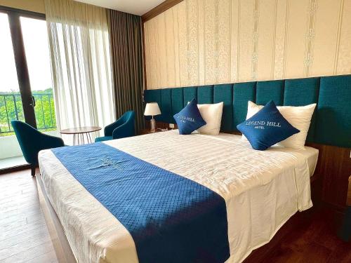a bedroom with a blue and white bed with blue pillows at Thái Nguyên Legend Hill in Thái Nguyên