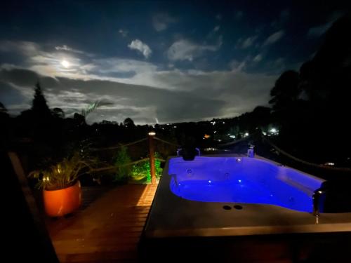 a blue bath tub on a deck at night at Entre-pinos Glamping WiFi Vista 360º in Guarne