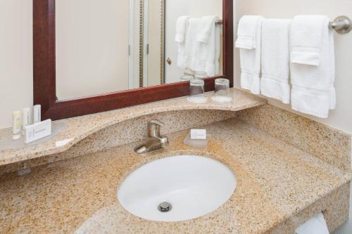 a bathroom with a sink and a mirror at SpringHill Suites by Marriott Lancaster Palmdale in Lancaster