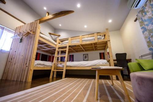 ein Schlafzimmer mit einem Etagenbett, einem Schreibtisch und einem Schreibtisch in der Unterkunft 日向サーフキャンプ212 in Hyuga