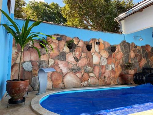 una pared de roca junto a una piscina en Casarão Pireneus en Pirenópolis