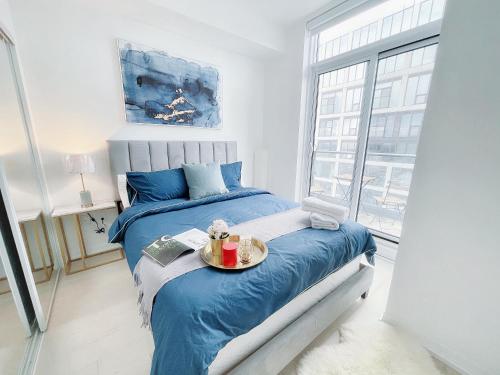 a bedroom with a bed with a tray of food on it at Boutique Penthouse-Live in the SKY with Amazing Lakeview! Downtown Toronto!B in Toronto