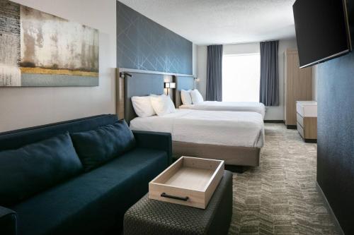 une chambre d'hôtel avec deux lits et un canapé dans l'établissement SpringHill Suites by Marriott Tulsa, à Tulsa