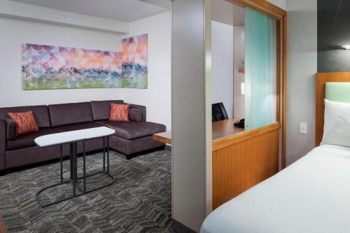 une chambre d'hôtel avec un lit et un canapé dans l'établissement SpringHill Suites by Marriott Salt Lake City Airport, à Salt Lake City