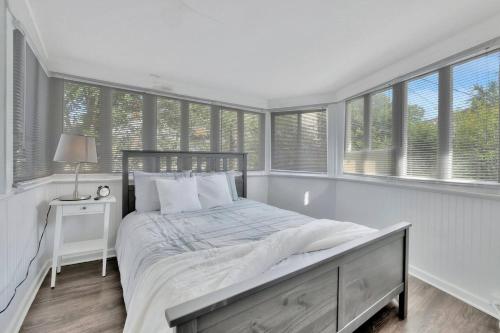 a white bedroom with a large bed and windows at Le château Tampa, Walk to Hyde Park & Amalie Arena in Tampa