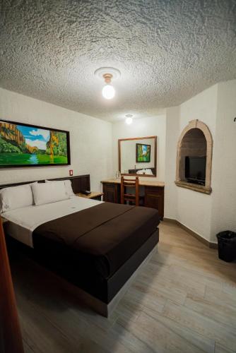 a bedroom with a large bed and a bathroom at Hotel Don Quijote Plaza - Guadalajara Centro Historico in Guadalajara