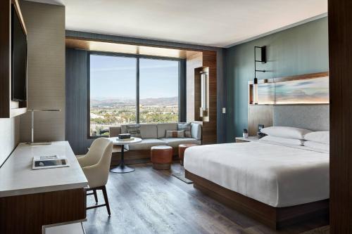 een slaapkamer met een bed en een woonkamer bij Marriott Irvine Spectrum in Irvine
