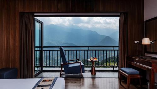a bedroom with a large window with a view of mountains at Bamboo Sapa Hotel in Sapa