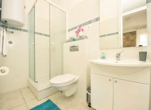 a white bathroom with a toilet and a sink at DreamWorksApartments-1 in Karlobag