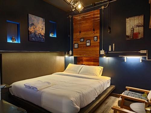 1 dormitorio con 1 cama blanca grande. en Tanwa Hotel, en Chiang Mai