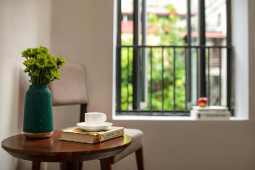 a table with a vase of flowers and a book at Bamboo Sapa Hotel in Sa Pa
