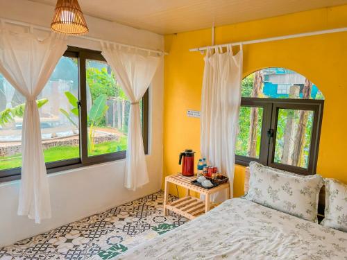 a bedroom with a bed and a window at Lacasa home&coffee Mộc Châu in Mộc Châu