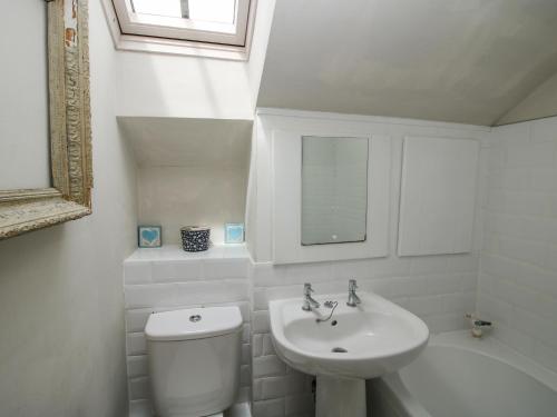 a white bathroom with a toilet and a sink at The Barn in Preesgreen