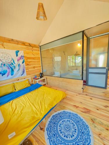 a bedroom with a yellow bed and a large mirror at Lacasa home&coffee Mộc Châu in Mộc Châu