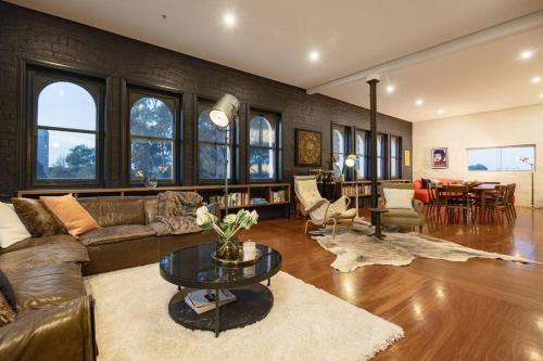 a living room with a couch and a table at The Penthouse on Gertrude St - Fitzroy in Melbourne