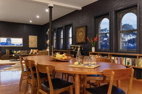 a dining room with a wooden table and chairs at The Penthouse on Gertrude St - Fitzroy in Melbourne