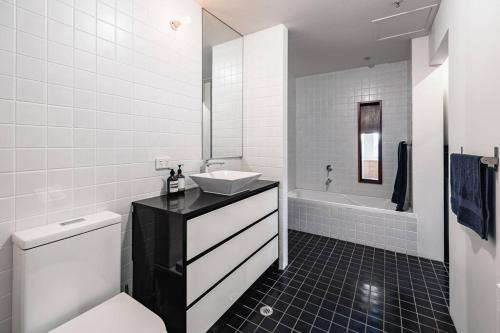 a bathroom with a sink and a toilet and a tub at The Penthouse on Gertrude St - Fitzroy in Melbourne