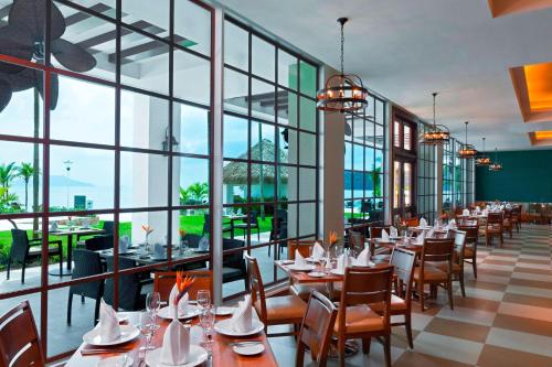 a restaurant with tables and chairs and large windows at The Westin Playa Bonita Panama in Playa Bonita Village