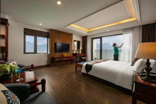 a woman standing on a balcony in a hotel room at Bamboo Sapa Hotel in Sa Pa