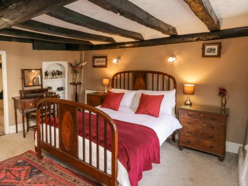 ブリクサムにあるHearthstone East Cottageのベッドルーム1室(大型ベッド1台、赤い枕付)