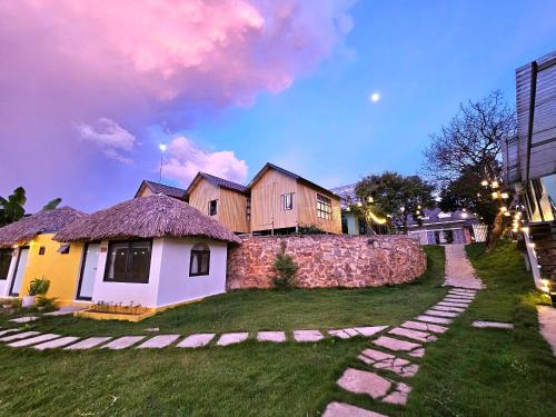 a house with a stone pathway in front of a yard at Lacasa home&coffee Mộc Châu in Mộc Châu
