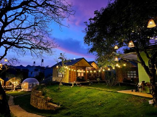 a house with lights in the yard at night at Lacasa home&coffee Mộc Châu in Mộc Châu
