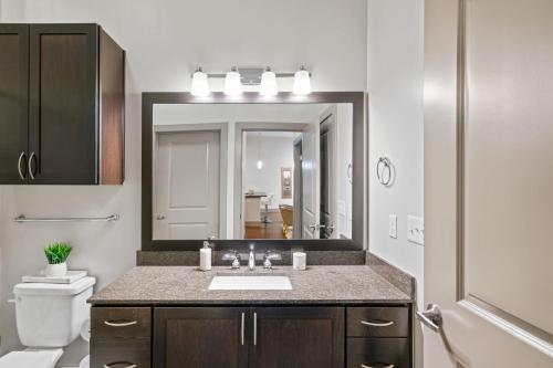 een badkamer met een wastafel en een grote spiegel bij Grand Luxury Premium Vaulted Ceilings in Woodbridge