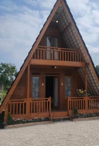 a large wooden house with a gambrel roof at Home Stay in Ambarita