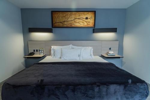 a bedroom with a large bed with blue walls at HOTEL LEMON GREEN -Zona Expo Frente al Centro de Convenciones in Guadalajara