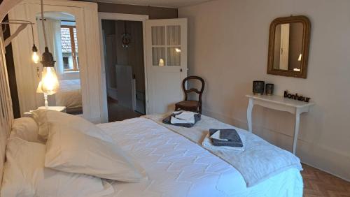 - une chambre avec un grand lit et un miroir dans l'établissement L'Atout Charme, à Bains-les-Bains