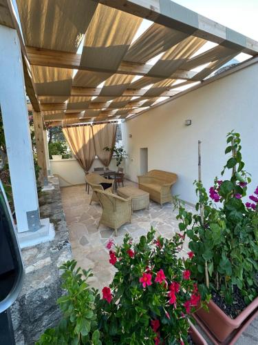 a patio with a table and chairs and flowers at Trullo Gnoffa in La Correggia