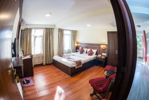 a hotel room with a bed and a mirror at Hotel Yambu kathmandu in Kathmandu