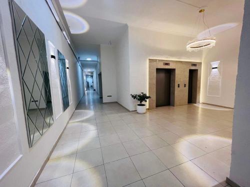 a hallway with white walls and a tile floor at Paradise Apartment in Batumi